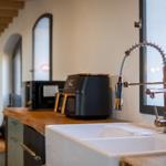 Küche mit großer Spüle, modernem Wasserhahn und Küchengeräten.