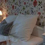Double bed with pillows, nightstand, and floral wallpaper