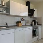 Kitchen with white cabinets, sink, dishwasher, and stove.