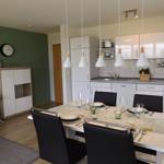 Kitchen and dining area with table, chairs, and pendant lights.