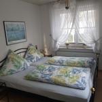 Schlafzimmer mit Bett, Fenster und Wandbild
