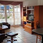 Wohn- und Essbereich mit Fernseher, Esstisch und Sitzgelegenheiten.