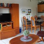 Wohnzimmer mit Essbereich, Küche und Ledersessel.