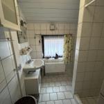 Bathroom with sink, window, and shower area.