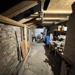 Attic with stone wall, wooden beams, and tools