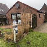 Red brick house with garden and patio. A small lighthouse stands in the foreground.