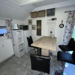 Kitchen with table, chairs, and view of green field.