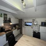 Kitchen with worktop, sink, stove, and cabinets.