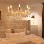 Bedroom with bed, chandelier, and wall picture.