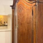 Antique cabinet with carvings, view into the kitchen