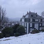 Black house with white windows on snowy slope