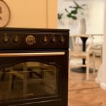 Black Gorenje stove with knobs and glass door in kitchen area