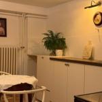 Kitchen with table, plant, and picture on the wall.