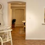Dining area with table, chairs, and wall clock. Passage to living and kitchen areas.