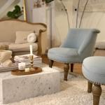 Living room with sofa, two chairs, and marble table.