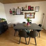 Dining room with table, chairs, and wall decor.