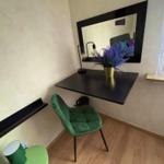 Desk with green chair and mirror on the wall