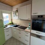 Kitchen with white cabinets, green refrigerator, and built-in oven.