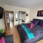 Bedroom with bed, TV, and view into the bathroom.