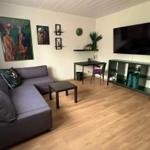 Living room with sofa, TV, and desk.