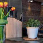 Küchenzeile mit Tulpen, Messerblock und Pflanze auf Arbeitsfläche