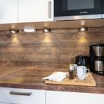 Küche mit Holzoberfläche, Mikrowelle und Kaffeemaschine.