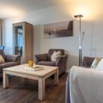 Wohnzimmer mit Sitzgruppe, Tisch und Wandbild.