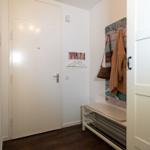 Eingangsbereich mit Schuhschrank, Haken und Kleidungsstücke.