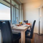 Esszimmer mit Tisch, Stühlen und Fensterblick