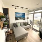 Wohnzimmer mit Sofa, Blick auf Strand und Terrasse.