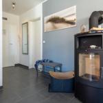 Eingangsbereich mit Kaminofen, Wandbild und Bänken