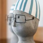 Ein dekorativer Kopf mit Brille und gestreifter Mütze.