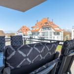 Terrasse mit Sitzgelegenheiten und Blick auf Wohnhäuser.