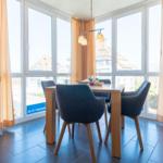 Esszimmer mit Tisch, Stühlen und großem Fensterblick.