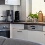 Küche mit Kochfeld, Spüle und integriertem Spülmaschinenbereich.