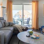 Wohnzimmer mit Sofa, Couchtisch und Balkonansicht