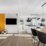 Living area with fireplace, TV, and dining area with table and chairs.