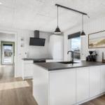 Kitchen with white built-in cabinetry, dark countertop, and window with view.