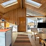 Living space with wooden walls, windows, and kitchen island.