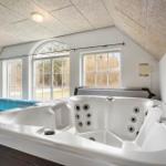 Whirlpool und Pool unter einem schrägen Dach mit Fenstern