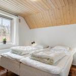 Schlafzimmer mit Doppelbett, Holzdecke und Fenster mit Blick.