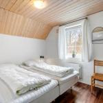 Zimmer mit zwei Betten, Holzdecke und Fenster mit Blick nach draußen.
