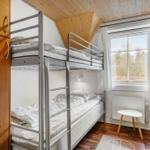 Zimmer mit Kletterbetten, Holzdecke und Fenster mit Blick auf Außengelände.