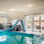 Indirekter Pool mit Rutsche und Sitzgelegenheiten im Inneren.