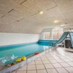 Indirektes Licht beleuchtet den Innenpool mit Rutsche und Spielzeug.