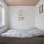 Bedroom with bed, window, and wall mural of a sailing ship.