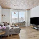 Living room with sofa, TV, and wooden floor