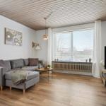 Living room with sofa, TV, and wooden floor.