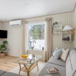 Living room with sofa, glass table, and TV mounted on the wall.