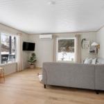 Living room with sofa, TV, and large windows for views.